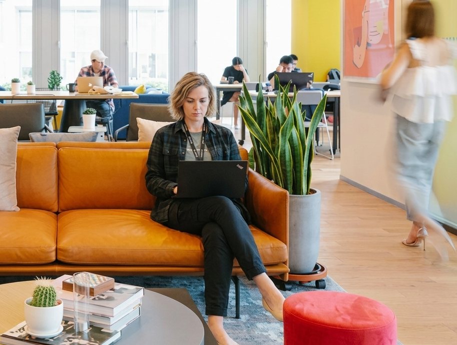 A professional working on a laptop in a bright open-plan office